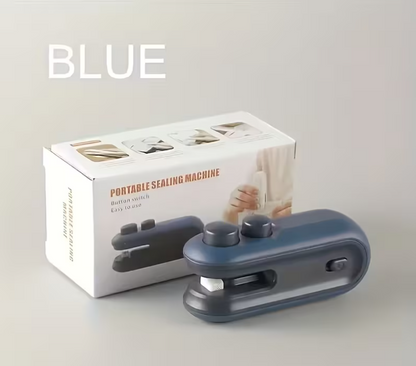 A portable sealing machine in a muted blue-gray color shown in front of its white retail box, with the word 'BLUE' printed in large white letters at the top left.